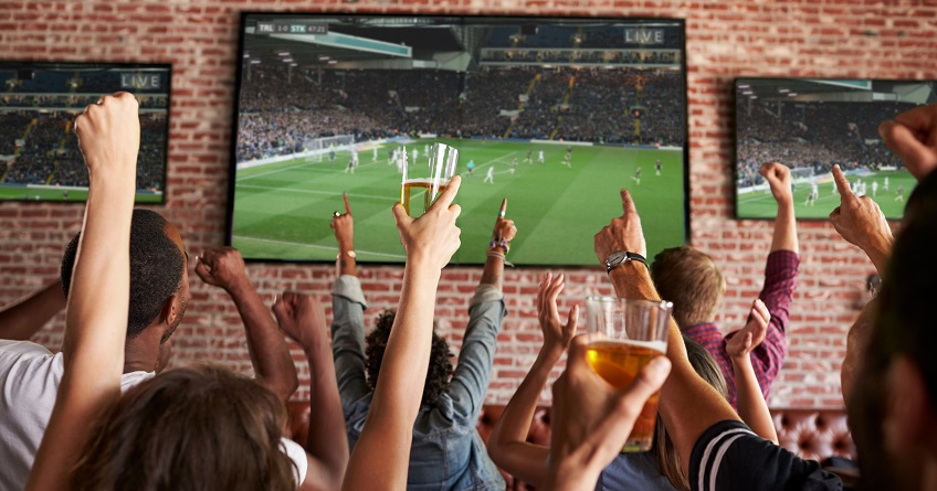 Group of people watching a game on a TV