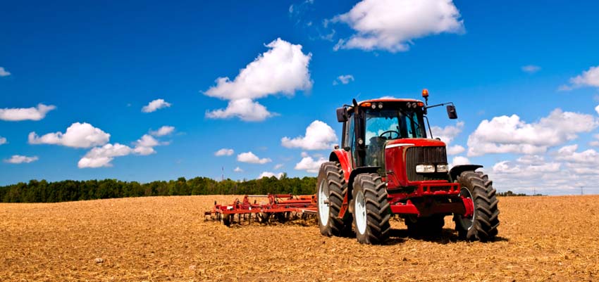 Red tractor out in a farm field