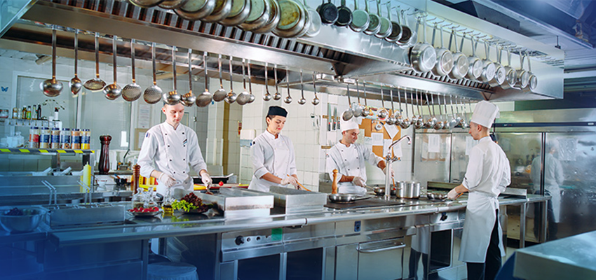 Four chefs cooking in a restaurant kitchen