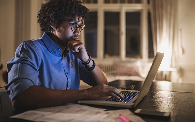 Man on laptop at night - Education & Scholarships