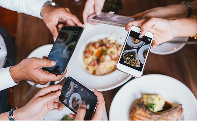 Three people photographing food bowls with phones - Marketing & Sales