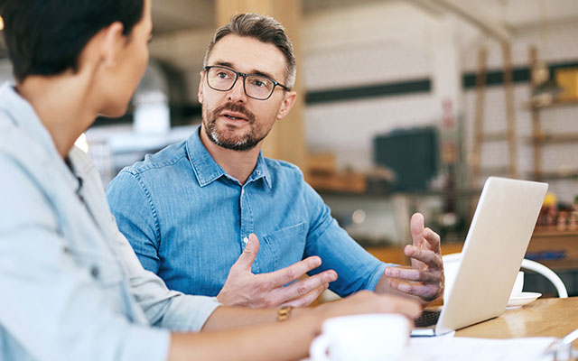 Two people sitting at a table talking
