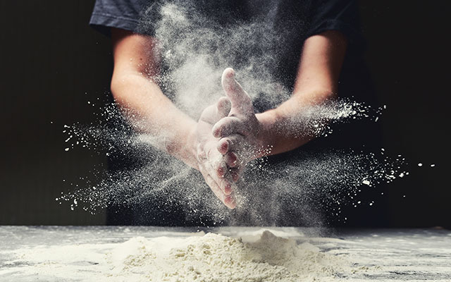 Chef rubbing hands with flour
